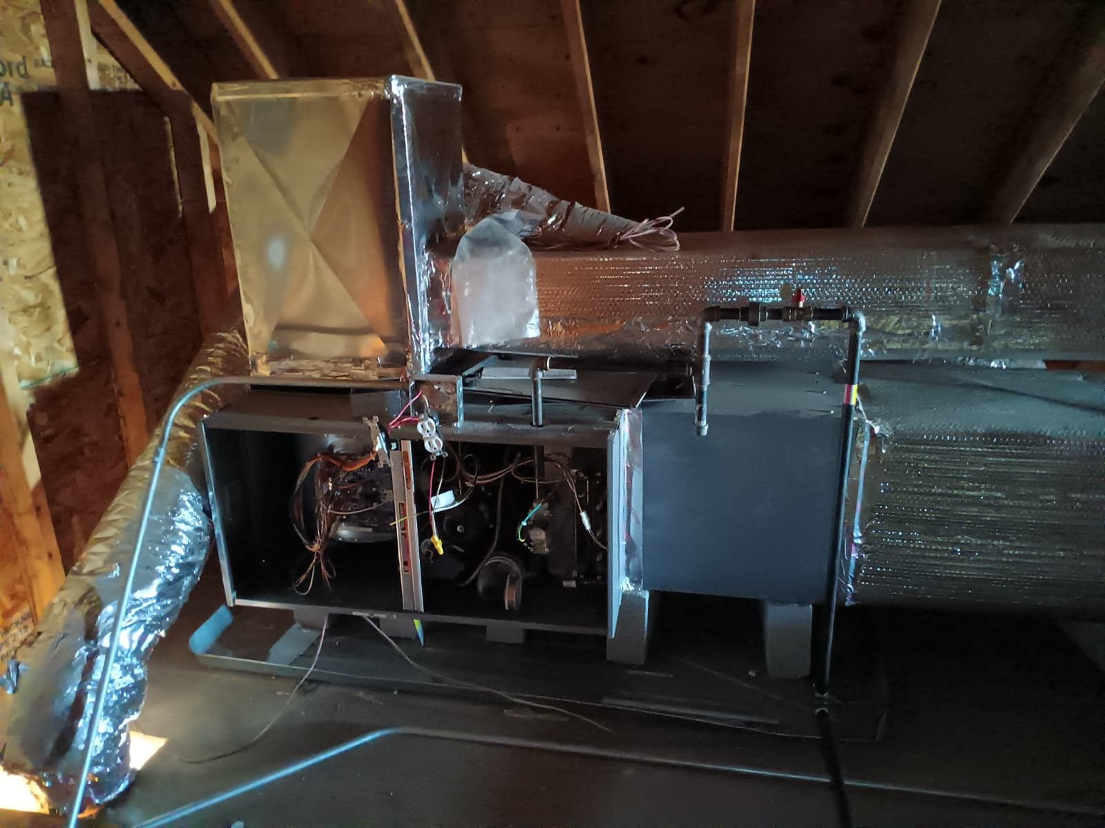 Attic-mounted air handler connected to an insulated supply trunk and flex duct